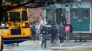 Petugas keamanan setempat memindahkan siswa menjauhi lokasi penembakan di Great Mills High School di Maryland, AS (20/3). Saat ini, sekolah masih ditutup untuk sementara waktu. Para siswa dievakuasi ke sekolah terdekat. (AP Photo / Alex Brandon)