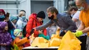 Para pegawai kebun raya memotong labu raksasa yang dipamerkan di Moskow, Rusia, pada 1 November 2020. Potongan labu kuning seberat 390 kg tersebut dibagikan kepada para pengunjung. (Xinhua/Maxim Chernavsky)
