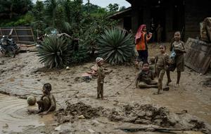 Kondisi lingkungan dan sanitasi yang kurang memadai pasca- bencana dapat memicu peningkatan kasus Infeksi Saluran Pernapasan Akut (ISPA), seperti batuk, pilek, hingga demam. Tampak dalam foto, anak-anak bermain di genangan lumpur di Pengidam, Aceh Tamiang, pada Senin 15 Desember 2025. (Yasuyoshi Chiba/AFP)