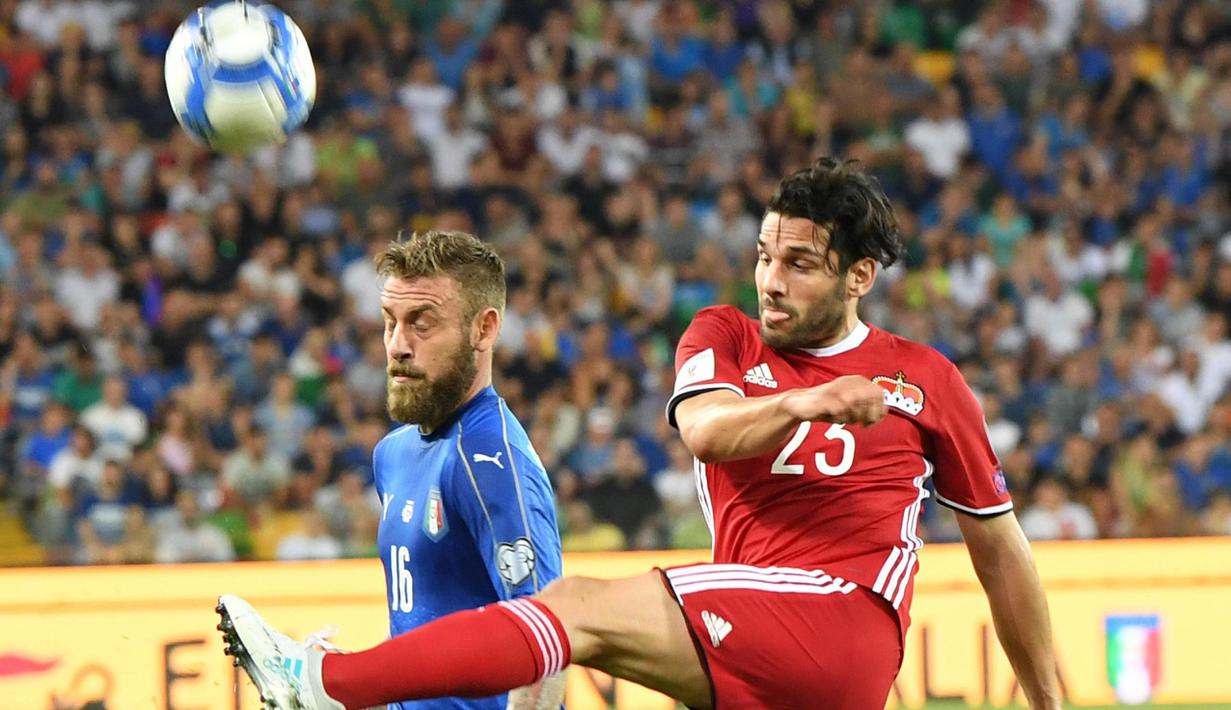 Pemain Italia, Daniele De Rossi (kiri) berduel dengan pemain Liechetenstein, Michele Polverino pada kualifikasi Piala Dunia 2018 grup G di Friuli Stadium, Udine, Italia, (11/6/2017).  (Alberto Lancia/ANSA via AP)
