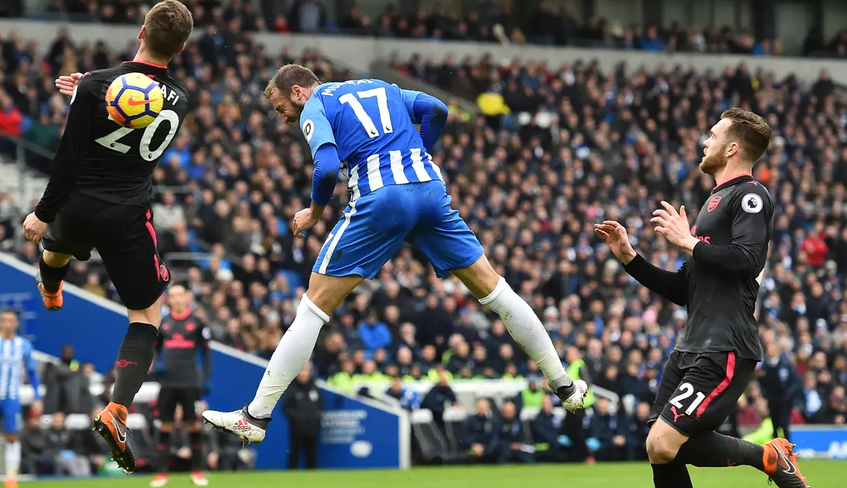 Aksi pemain Brighton, Glenn Murray (tengah) menyundul bola ke gawang Arsenal pada laga Premier League di American Express Community Stadium, Brighton, (4/3//2018). Arsenal kalah 1-2. (AFP/Glyn Kirk)