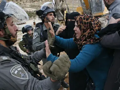 Perempuan Palestina terlibat cekcok dengan polisi Israel saat memprotes pembongkaran rumah di Desa Al-Dirat, dekat kota Hebron, Tepi Barat (16/1/2020). Pembongkaran itu menurut otoritas Israel dilakukan karena rumah dibangun tanpa izin. (AFP/Hazem Bader)