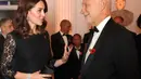Kate Middleton berbincang dengan CEO Anna Freud, Peter Fonagy pada sebuah acara amal di Kensington Palace, London, Selasa (7/11). Kate juga tampak membawa tas kecil hitam yang digunakan untuk menutup bagian perutnya. (AP/Frank Augstein, pool)