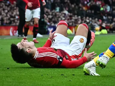Pemain Manchester United, Lisandro Martinez mengeram kesakitan dalam laga lanjutan Liga Inggris 2024/2025 melawan Crystal Palace di Old Trafford, Manchester, Inggris, Minggu (02/02/2025). (AFP/Paul Ellis)