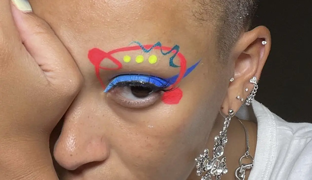 <p>Alis matanya pun cukup berwarna dengan gambar space, dipadukan eyeliner wings biru neonnya.@dojacat</p>