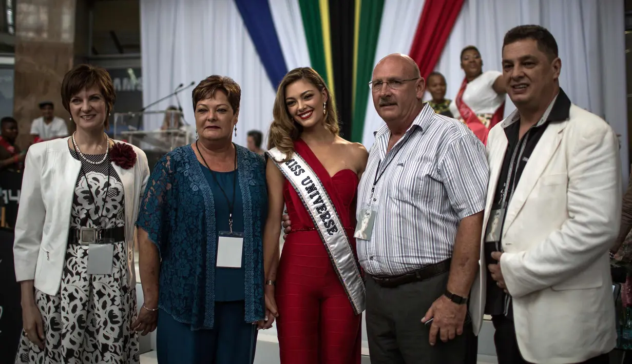 Demi-Leigh Nel-Peters (tengah) berpose dengan ibu tirinya Elsabie Peters (kiri), ayahnya Bennie Peters (kanan), ibunya Anne-Marie Steenkamp (kedua kiri) dan ayah tiri Johan Steenkamp saat dia tiba di Johannesburg (24/1). (AFP Photo/Gulshan Khan)