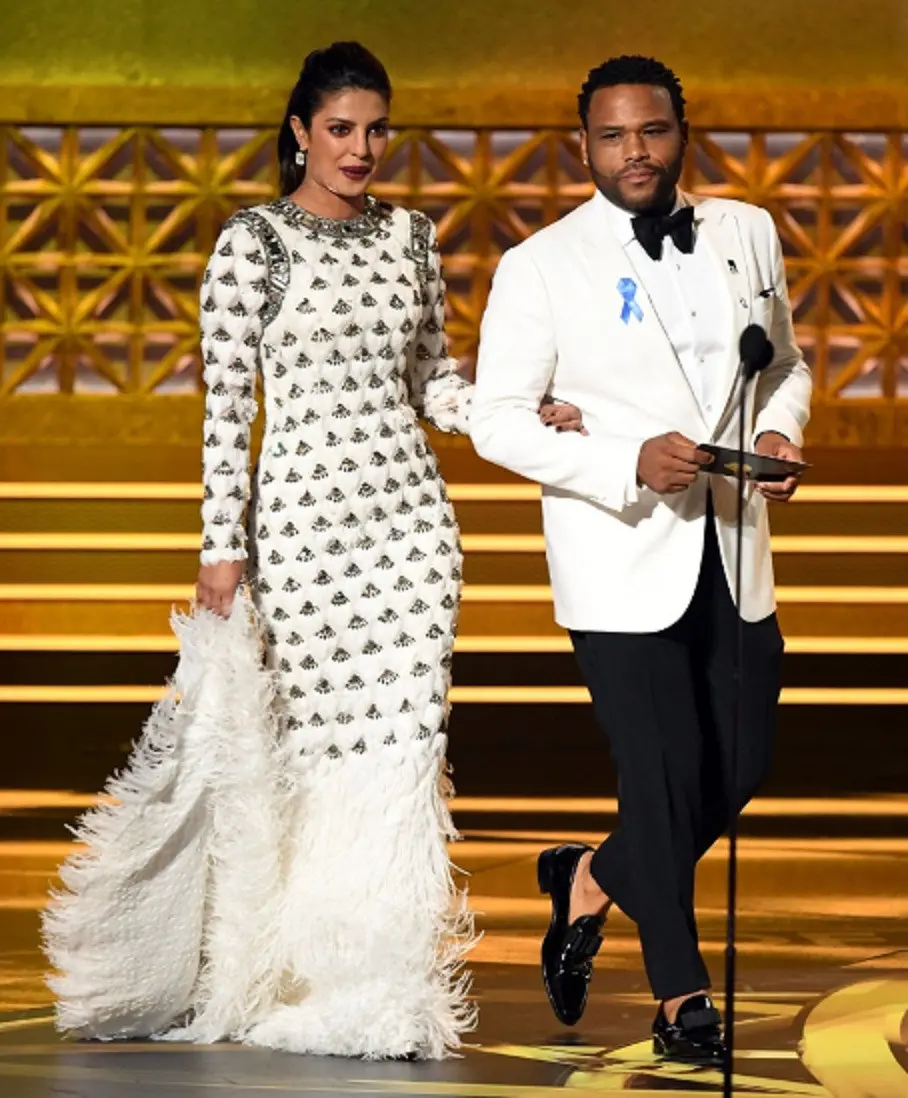 Priyanka Chopra menggandeng Anthony Anderson saat berjalan ke arah podium di Emmy Awards 2017 (ABCNews)