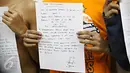 Salah seorang anak menunjukkan surat pernyataan yang dibuatnya di Polda Metro Jaya, Jakarta, Minggu (18/10). Polisi mengamankan ratusan remaja yang berbuat onar menjelang laga final Piala Presiden di GBK. (Liputan6.com/Immanuel Antonius)