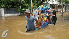 Warga membantu mendorong gerobak penjual prabotan di komplek Polri jalan Pondok Karya, Mampang, Jakarta, Kamis (21/4). Banjir setinggi 120cm disebabkan meluapnya Kali Mampang. (Liputan6.com/Gempur M Surya)