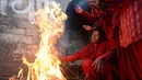 Para wanita hindu Nepal menghangatkan badan usai mandi di Sungai Bagmati saat Festival Swasthani, Kathmandu, Selasa (20/1/2015). (AFP Photo/Prakash Mathema)