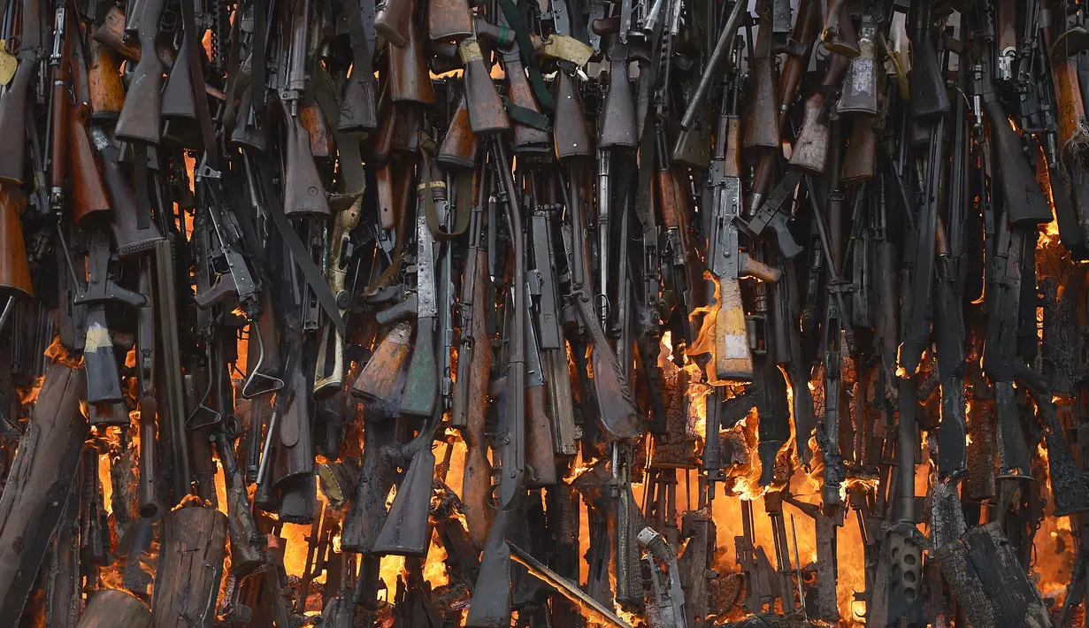 Ratusan senjata ilegal yang berhasil disita pihak keamanan Kenya dibakar di Kajiado County, Kenya (15/11). Pembakaran ini adalah upaya pemerintah Kenya untuk mengurangi tindak kejahatan yang mengunakan senjata api. (AFP/Tony Karumba)