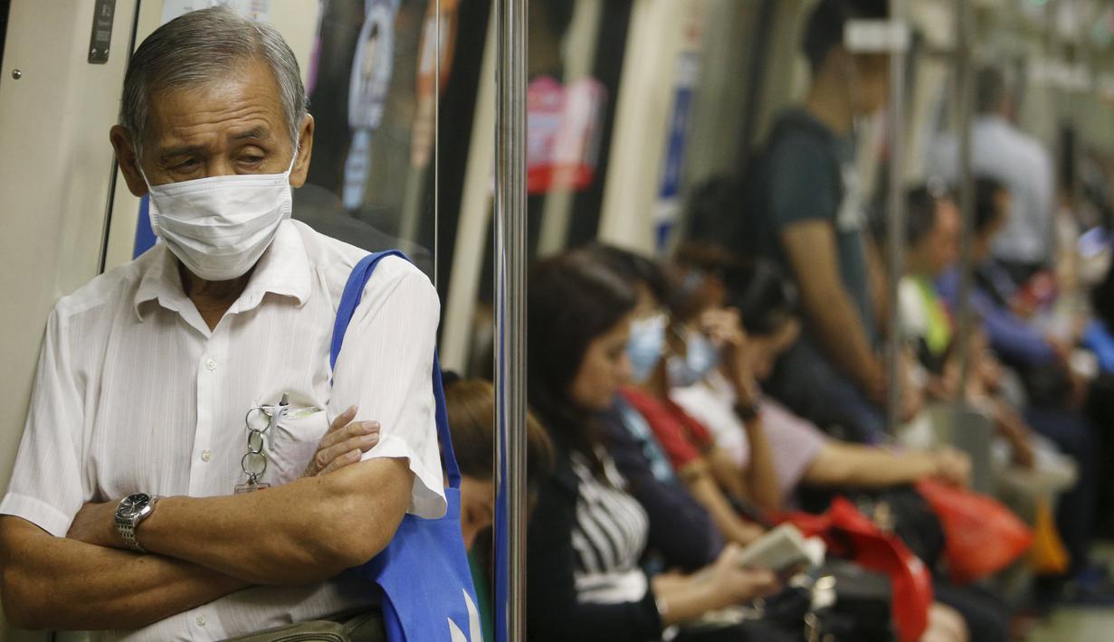 Warga memakai masker saat berada di dalam kereta api, Singapura (25/9/2015). Menurut Badan Lingkungan Nasional Singapura kabut Polutan Standar Indeks (PSI) mencapai tinggi 341 pada hari Jumat. (REUTERS/Edgar Su)