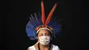 Sonia Vilacio (46) dari kelompok etnis pribumi Sateré Mawé mengenakan pakaian tradisional sukunya dan masker saat pandemi virus corona COVID-19 di Manaus, Brasil, Rabu (27/5/2020). Sonia Vilacio pernah jatuh sakit dengan tanda-tanda terpapar COVID-19. (AP Photo/Felipe Dana)