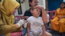Dinas Kesehatan Pemerintah Kota Surabaya, Jawa Timur menggelar program imunisasi massal pada Senin 15 September 2025. (Juni KRISWANTO/AFP)