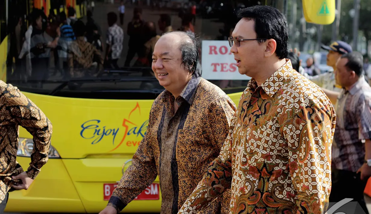 Gubernur DKI Jakarta Basuki Tjahaja Purnama berjalan beriringan dengan Dato Sri Tahir saat melakukan serah terima 5 unit bus tingkat gratis, Rabu (10/12/2014). (Liputan6.com/Faizal Fanani)
