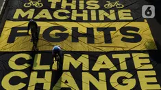 Pesepeda melintas di atas banner yang dibentangkan aktivis Greenpeace dan Bike2Work di Jalan Jenderal Sudirman, Jakarta, Minggu (5/6/2022). Aksi untuk mengkampanyekan penggunaan sepeda sebagai kendaraan ramah lingkungan dan solusi pembangunan Jakarta Kota Ramah Pesepeda. (Liputan6.com/Helmi Fithriansyah)