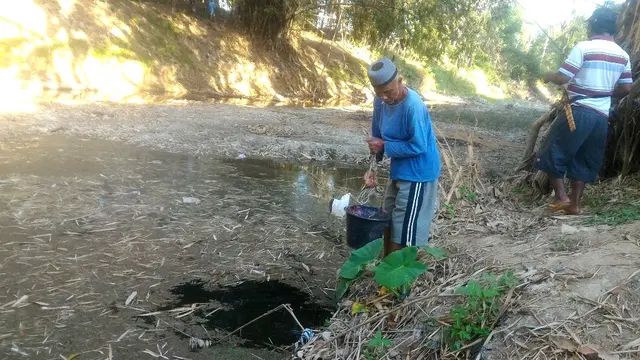 Seorang warga Dusun Cibriluk, Desa Cinangsi, Kecamatan Gandrungmangu, Cilacap menimba air di sungai lantaran sumurnya sudah mengering. (Foto: Liputan6.com/Muhamad Ridlo)