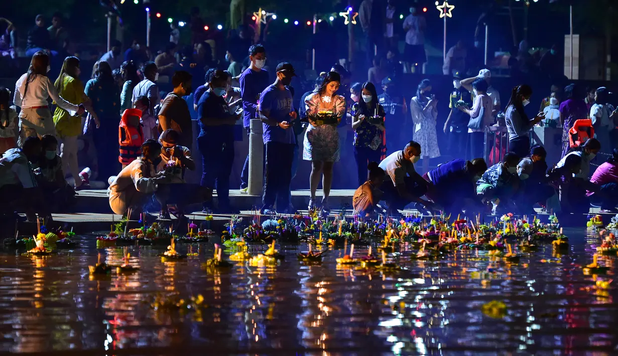 Orang-orang melepaskan lentera mengambang ke sungai selama festival Loy Krathong di provinsi Narathiwat, Thailand selatan (8/11/2022). Festival ini biasanya berlangsung pada akhir musim hujan ketika bulan purnama menyala di langit pada November. (AFP/Madaree Tohlala)