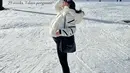 Jessica Mila tampil dengan padding jaket putih dipadukan celana hitam serasi dengan tas Chanelnya. Serta sepatu boots putih. [@jscmila]