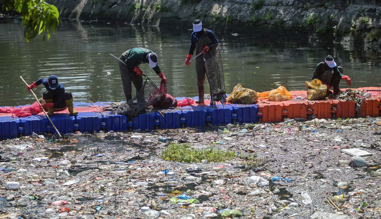 Selain mengangkat sampah, relawan juga memilah jenis limbah yang terbawa arus sungai. Tampak dalam foto, aktivis dari Ecoton (Ecological Observation and Wetlands Conservation) bersama pekerja dari Dinas Lingkungan Hidup Pemerintah Kota Surabaya, Jawa Timur, membersihkan sampah dari Sungai Kali Tebu, pada Senin 11 Mei 2026. (JUNI KRISWANTO/AFP)