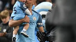 Pablo Zabaleta menggendong putranya Asier usai pertandingan melawan West Bromwich Albion di Liga Inggris di Stadion Etihad, Manchester,(16/5). Zabaleta kabarnya akan berlabuh ke West Ham dengan kontrak dua tahun. (AFP Photo/Paul Ellis)