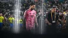 Pemain Inter Miami, Lionel Messi berjalan ke luar lapangan saat jeda babak pertama dalam laga Grup A Piala Dunia Antarklub 2025 melawan Palmeiras di Hard Rock stadium, Miami, Amerika Serikat, Selasa (24/06/2025) WIB. (AFP/Patricia De Melo Moreira)