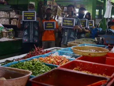 Petugas pengelola pasar melakukan kampanye dengan membawa poster kepada pedagang di Pasar Jatinegara, Jakarta, Kamis (11/6/2020). Kampanye ini sebagai bentuk kepedulian terhadap pedagang dan pembeli pasar untuk saling mengingatkan guna menekan penyebaran Corona COVID-19. (merdeka.com/Imam Buhori)