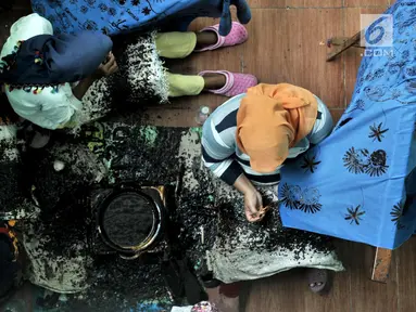 Pengrajin melakukan proses pencantingan saat menyelesaikan pembuatan kain batik Betawi di rumah produksi Batik Seraci, Kampung Kebon Kelapa, Bekasi, Jawa Barat, Selasa (2/10). Rumah Batik Seraci berdiri sejak 2010. (Merdeka.com/Iqbal Nugroho)