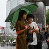 Orang-orang mencari berlindung dari hujan lebat yang terisolasi di distrik Akihabara Tokyo (13/8/2022). Hujan lebat yang dibawa oleh Badai Tropis Meari melanda daerah tersebut. (AFP/ Richard A. Brooks)