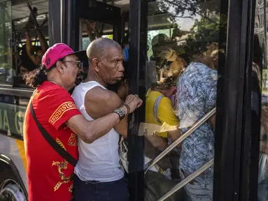 Orang-orang berdesakan untuk masuk ke dalam bus yang penuh dengan pelanggan di Havana, Kuba, Kamis, 6 April 2023. (AP Photo/Ramon Espinosa)