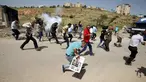 Wartawan Palestina berlari berhamburan setelah gas air mata ditembakkan pasukan Israel saat meliput aksi protes yang menyerukan pembebasan wartawan Palestina, Omar Nazzal di dekat Penjara Ofer Israel di Ramallah, Israel (26/4).(REUTERS / Mohamad Torokman)