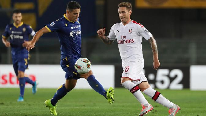 Gelandang AC Milan, Lucas Biglia berebut bola dengan pemain Hellas Verona, Mariusz Stepinski pada pertandingan pekan ketiga Liga Italia di Stadio Marc'Antonio Bentegodi (15/9/2019). AC Milan menang tipis atas Hellas Verona 1-0. (Simone Venezia/ANSA via AP)