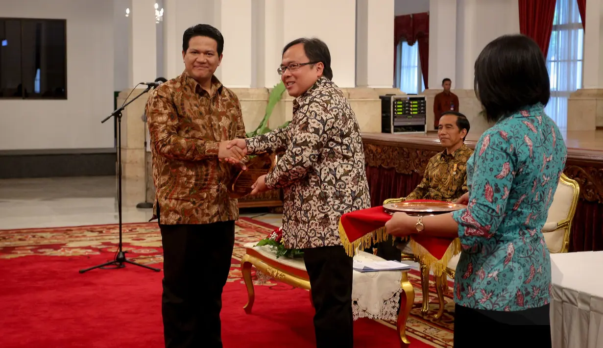 Menkeu Bambang Brodjonegoro memberikan penghargaan kepada Ketua KPU Husni Kamil Manik pada acara pemberian penghargaan dalam rangka penerimaan pajak 2015 dari Kementerian Keuangan di Istana Negara, Jakarta, Rabu (20/5). (Liputan6.com/Faizal Fanani)