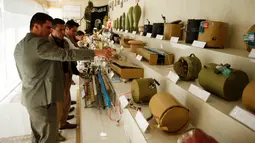 Tentara Kurdi Peshmerga melihat melihat-lihat mortir dan macam-macam bom yang digunakan oleh militan negara Islam (ISIS) di sebuah museum di Erbil, Irak, 12 Mei 2019. 'Museum ISIS' tersebut dibuka oleh militer Peshmerga. (REUTERS/Azad Lashkari)