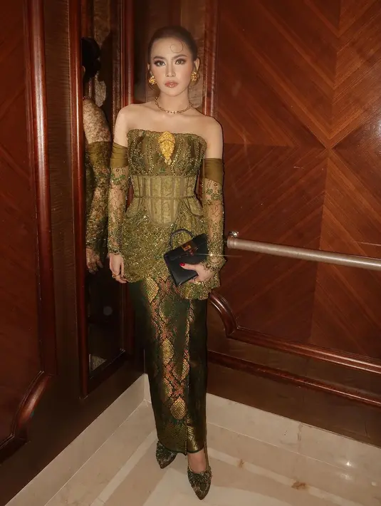 Mahalini Raharja tampil paripurna dengan desain kebaya yang paling beda. Menampilkan strapless top dengan detail korset dan asymmetrical ruffle. Dipadukan dengan rok tenun dan gloves brokat yang jadi aksen sabrina. [@mahaliniraharja].