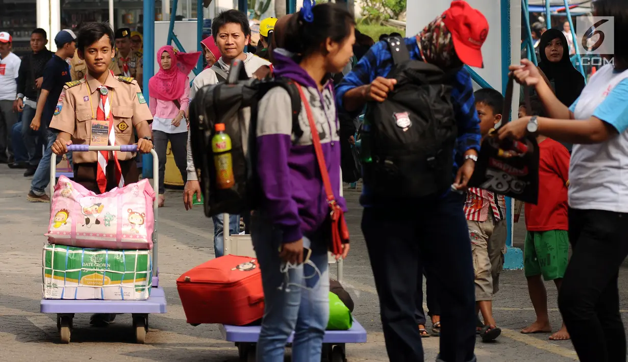Seorang anggota Pramuka mendorong barang bawaan pemudik di kawasan Pelabuhan Merak, Banten, Kamis (22/6). Di Pelabuhan Merak, sejumlah anggota Pramuka diterjunkan untuk membantu pemudik membawa barang bawaan. (Liputan6.com/Helmi Fithriansyah)