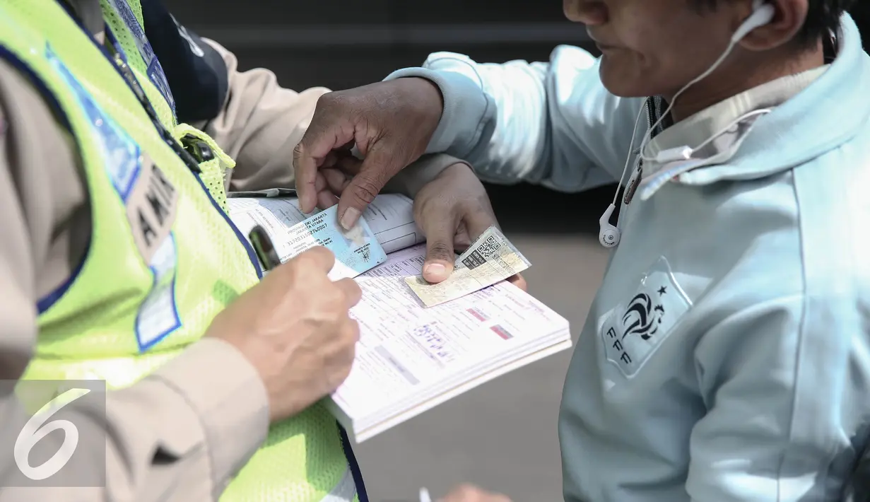 Petugas memeriksa surat kelengkapan berkendara saat operasi patuh jaya dikawasan Thamrin, Jakarta, Selasa (24/5/2016). Selama Operasi Patuh Jaya 2016, Ditlantas Polda Metro Jaya mencatat terjadi 38.622 pelanggar lalu lintas. (Liputan6.com/Faizal Fanani)