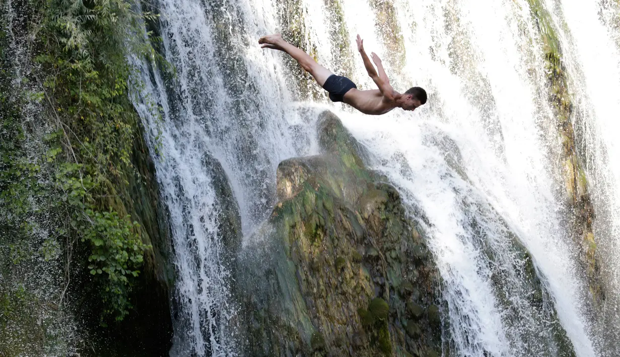 Peserta melompat dari atas air terjun saat mengikuti lomba melompat air terjun internasional ke-4 di Kota Jajce, Bosnia (5/8). Lomba melompat dari atas air terjun internasional digelar setiap tahun. (AP Photo/Amel Emric)