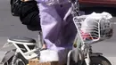 Seorang wanita menggunakan pakaian pelindung dari sinar matahari saat mengendarai sepeda listrik di Handan, provinsi Hebei, Rabu (12/7). Sebanyak 21 provinsi di China diterpa gelombang panas dengan suhu maksimum mencapai 50 derajat Celsius. (STR / AFP)