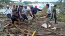 Warga mengevakuasi kantong jenazah berisi jasad korban tsunami di Palu, Sulawesi Tengah , Sabtu (29/9). Gelombang tsunami setinggi 1,5 meter yang menerjang Palu terjadi setelah gempa bumi mengguncang Palu dan Donggala. (AP Photo)