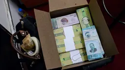 Sejumlah uang lokal ditumpuk didalam kardus di Caracas, Venezuela (15/12). Mata uang lokal yang bernama Panal ini diluncurkan di lingkungan kelas pekerja "23 de Enero". (AFP Photo/Federico Parra)
