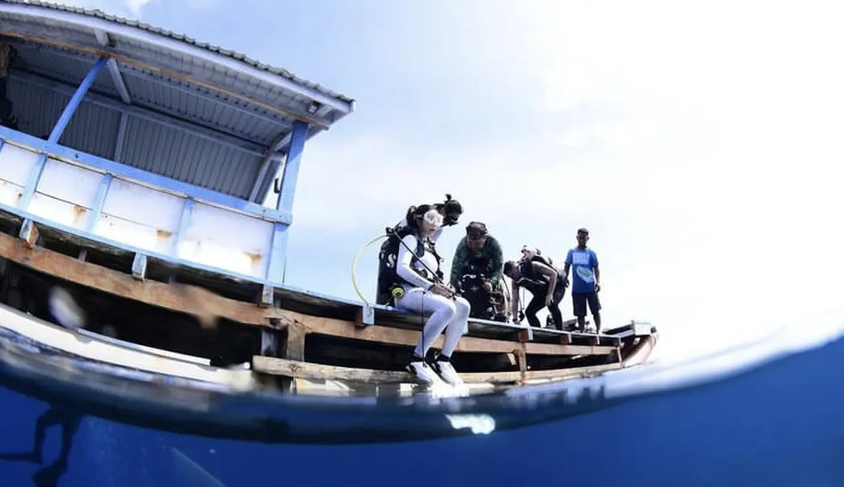 <p>Sebelum diving, ia terlihat mengenakan baju selam berwarna putih. @gisel_la</p>