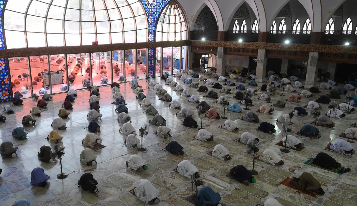 Umat muslim menerapkan jaga jarak aman atau physical distancing saat melaksanakan salat Jumat berjemaah selama Ramadan di Masjid Data Darbar, Lahore, Pakistan, Jumat (1/5/2020). Umat muslim dunia melaksanakan Ramadan tahun ini di tengah pandemi COVID-19. (ARIF ALI/AFP)