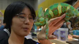Seorang wanita memegang seekor chameleon dalam Pameran Hewan Peliharaan Thailand 2020 di Bangkok International Trade and Exhibition Center (BITEC), Bangkok, Thailand, 3 September 2020. Ajang yang digelar selama empat hari itu akan berlangsung hingga 6 September. (Xinhua/Rachen Sageamsak)