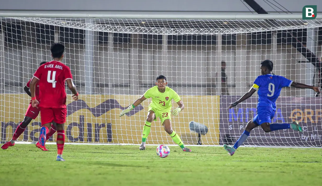 Kiper Timnas Indonesia, Ikram Al Giffari (tengah) bersiap menerima tendangan pemain Maladewa, Shanaan Rashaad (kanan) pada laga Grup F Kualifikasi Piala Asia U-20 2024 di Stadion Madya, Senayan, Jakarta, Rabu (25/09/2024). (Bola.com/Bagaskara Lazuardi)