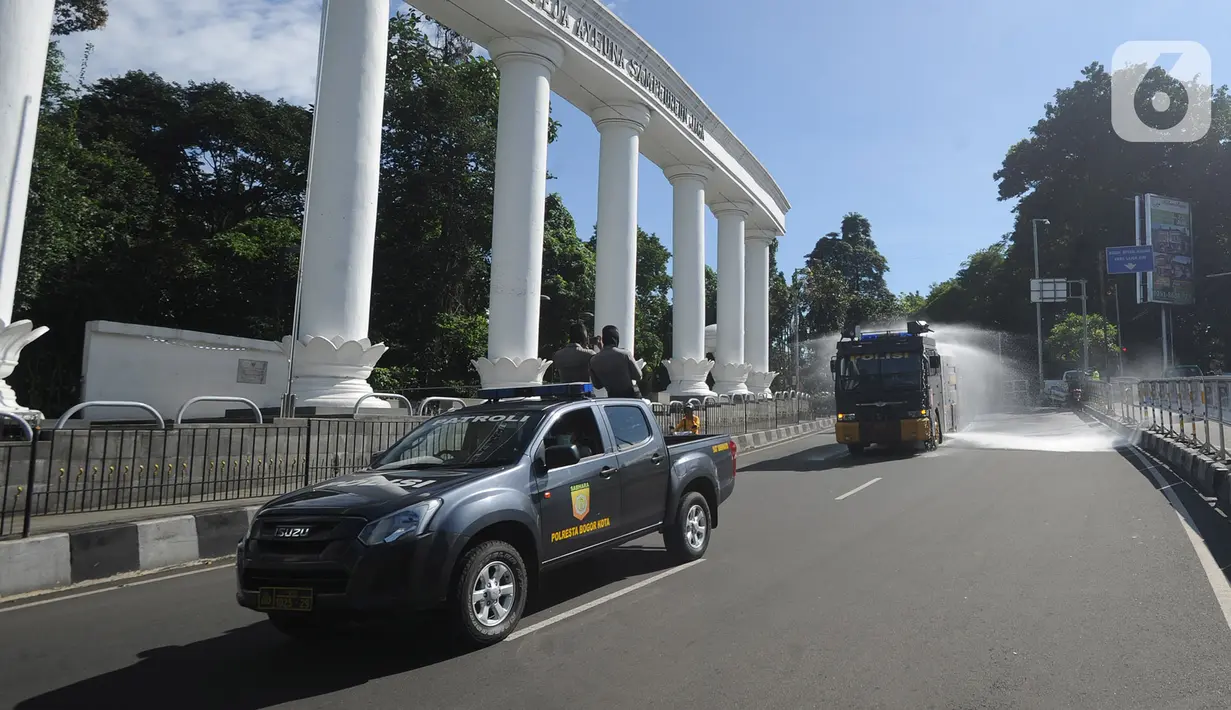Petugas kepolisian Polresta Bogor menyemprotkan cairan disinfektan menggunakan mobil Water Cannon di kawasan Tugu Kujang, Bogor, Selasa (31/3/2020). Penyemprotan disinfektan secara menyeluruh di wilayah Kota Bogor itu guna mencegah memutus rantai penyebaran virus corona. (merdeka.com/Arie Basuki)
