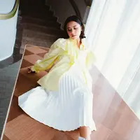 Ziva Magnolya tampil bright di potret ini. Ia mengenakan kemeja kuning dengan aksen ruffle yang dipadukan dengan pleated skirt putih dan ankle boots heels. [instagram/zivamagnolya]