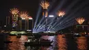 Kembang api terlihat di atas Pelabuhan Victoria pada tengah malam pada Tahun Baru, Minggu (1/1/2022). Malam pergantian tahun identik dengan pesta kembang api. (AP Photo/Anthony Kwan)