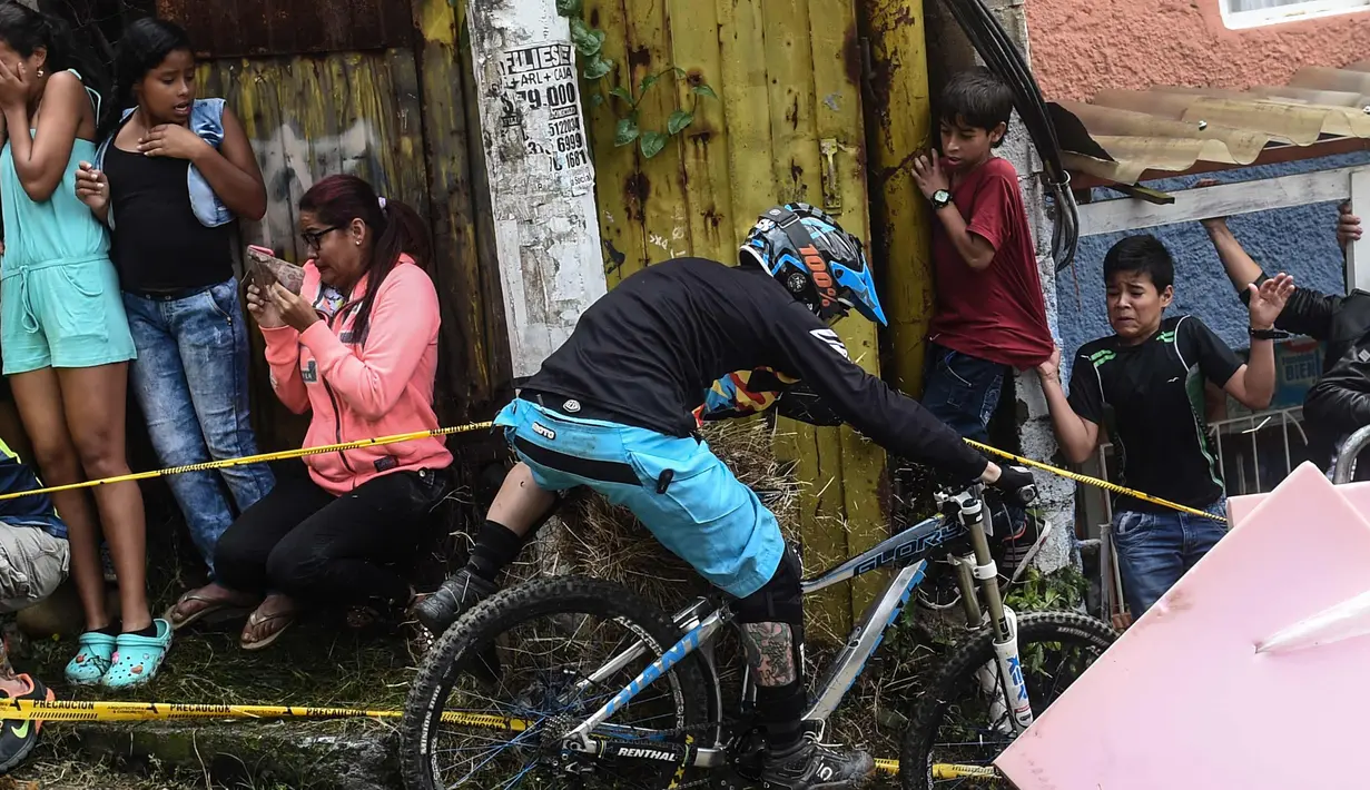 Peserta lomba sepeda terjatuh saat mengikuti balapan Urban Bike Inder Medellin di gubuk comuna 1 di Medellin, Antioquia department, Kolombia (19/11). (AFP Photo/Joaquin Sarmiento)