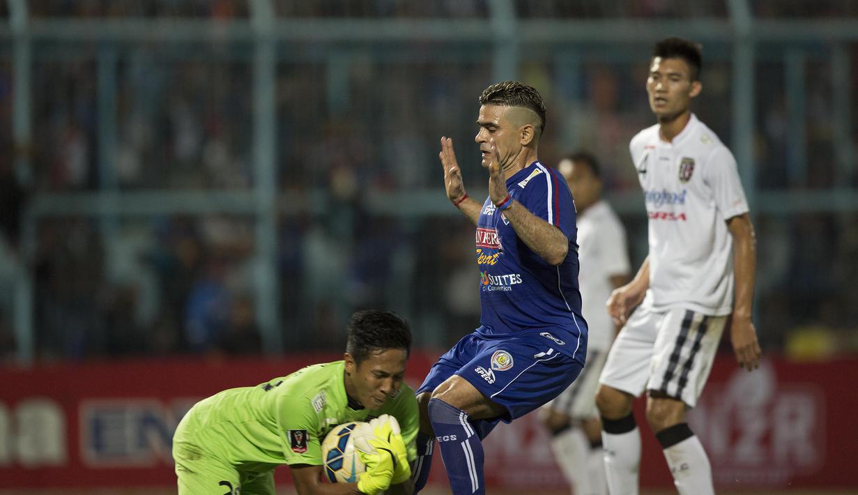 Kiper Bali United, I Ngurah Komang Aria mengamankan bola dari jangkauan striker Arema Cronus, Cristian Gonzales pada laga perempat final Piala Presiden di Stadion Kanjuruhan, Malang, Sabtu (19/9/2015). (Bola.com/Vitalis Yogi Trisna)